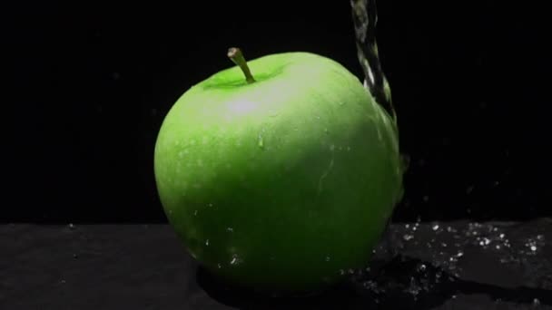 Zoet Water Gieten Een Groene Apple Een Zwarte Achtergrond Slow — Stockvideo