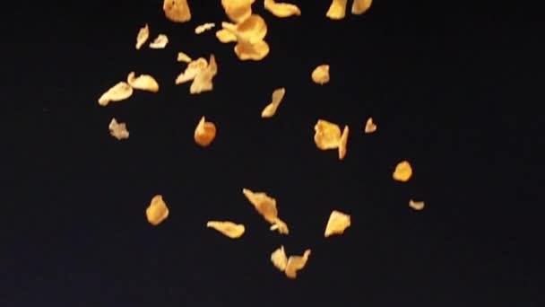 Хрустящие Желтые Кукурузные Хлопья Падают Землю Черном Фоне Slow Motion — стоковое видео