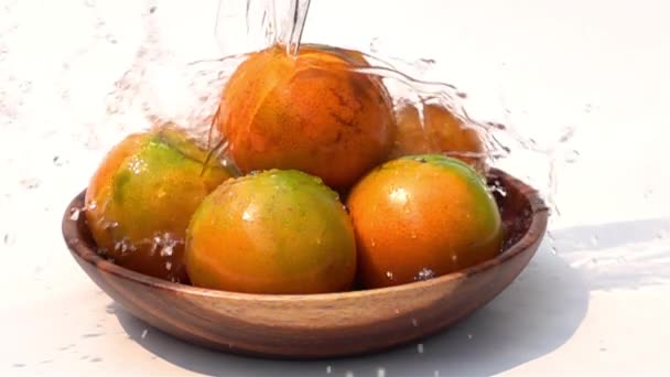在慢动作中 将淡水倒在白色背景上的一堆橘子上 — 图库视频影像