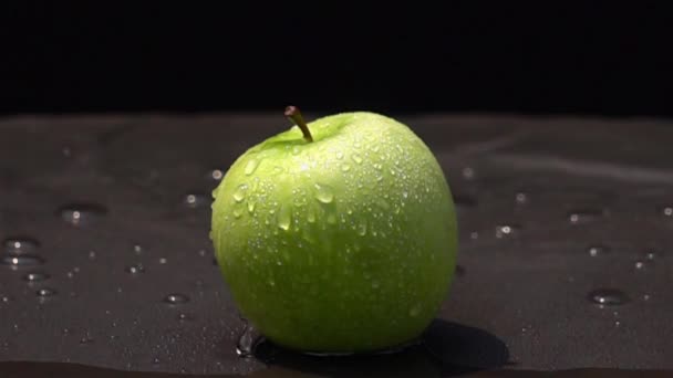 慢动作中黑色背景上的绿色苹果上的水滴 — 图库视频影像