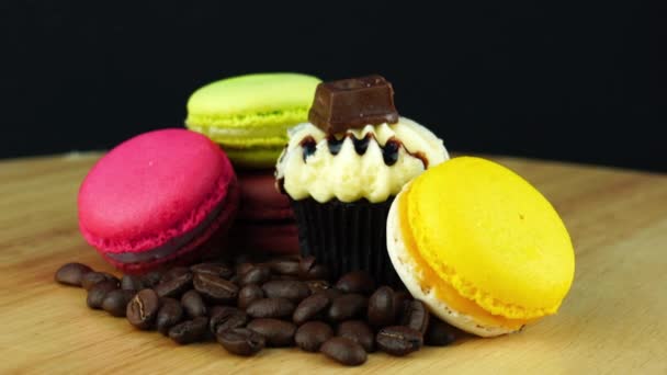 美味的五颜六色的马卡龙 木板上有一堆咖啡豆和巧克力纸杯蛋糕 — 图库视频影像