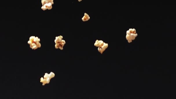 新鲜爆米花在慢动作的黑色背景上掉落在地面 — 图库视频影像