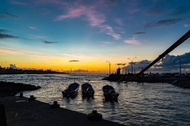 Silhouette of fisherman port of Hanga Roa Village at sunset in E clipart
