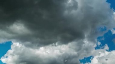 Güneşli gün Time Lapse mavi gökyüzünde karanlık kabarık yağmur bulutları akışı