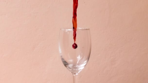 Giet Rode Wijn Een Glas Een Roze Achtergrond Slow Motion — Stockvideo