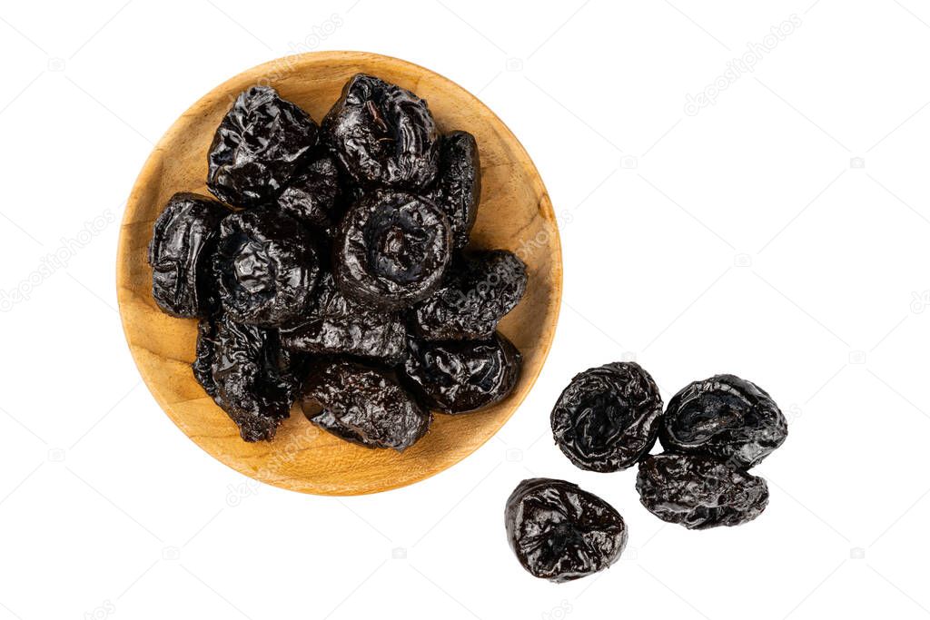 Top view of dried pitted prunes in wooden plate and prunes on the floor over white background with clipping path.