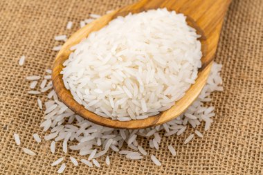 Tahta bir kaşık içinde çuvaldaki yasemin pilavı yığını.,