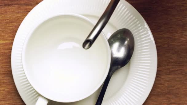 将咖啡倒入木制桌子上的白色陶瓷咖啡杯 用金属罐把黑咖啡倒入白杯 — 图库视频影像