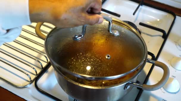 男性高齢者は 金属鍋にジャガイモと玉ねぎと自家製の牛肉スープを調理しています 先輩が鍋から肉とジャガイモを一切れ出して — ストック動画