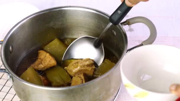 Senior ladling homemade chicken soup from metal pot on a metal sieve to ceramic bowl. — Stock Footage Senior Ladling Homemade Chicken Soup Metal Pot Metal Sieve Ceramic Royalty Free Stock Footage