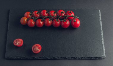 taş siyah bir arka plan üzerinde kiraz domates 