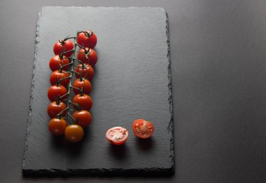 taş siyah bir arka plan üzerinde kiraz domates 