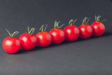 taş siyah bir arka plan üzerinde kiraz domates 