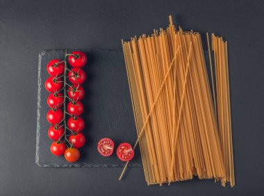 Makarna, tomates siyah bacground kirazlı