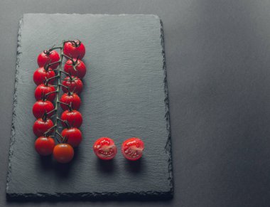 taze domates taş siyah bir arka plan üzerinde kiraz Şubesi 