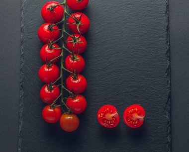 taze domates taş siyah bir arka plan üzerinde kiraz Şubesi 