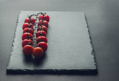 taze domates taş siyah bir arka plan üzerinde kiraz Şubesi 