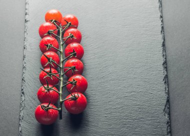 taze domates taş siyah bir arka plan üzerinde kiraz Şubesi 