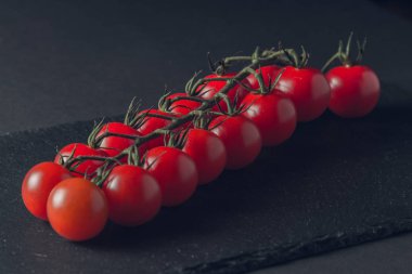 taze domates taş siyah bir arka plan üzerinde kiraz Şubesi 