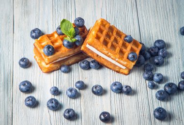 ahşap arka plan üzerinde beyaz bir tabakta nane ile yaban mersini