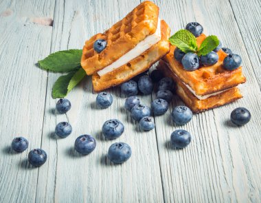 ahşap arka plan üzerinde beyaz bir tabakta nane ile yaban mersini