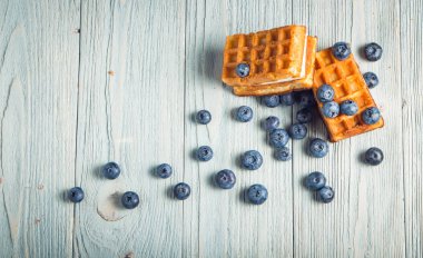 ahşap arka plan üzerinde beyaz bir tabakta nane ile yaban mersini