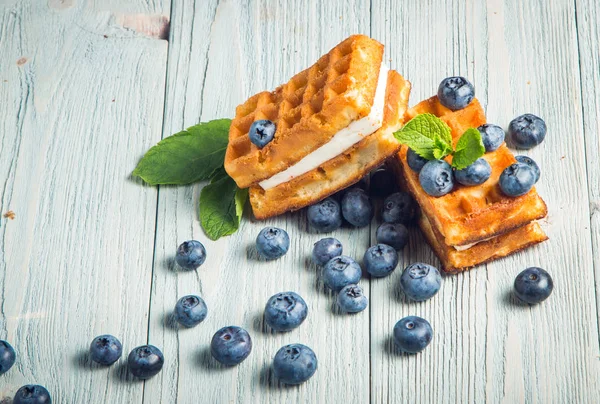 ahşap arka plan üzerinde beyaz bir tabakta nane ile yaban mersini