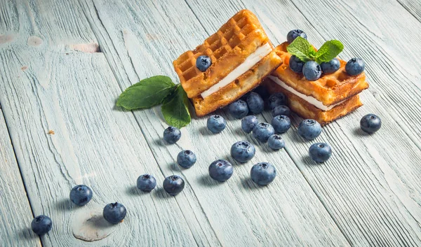 ahşap arka plan üzerinde beyaz bir tabakta nane ile yaban mersini