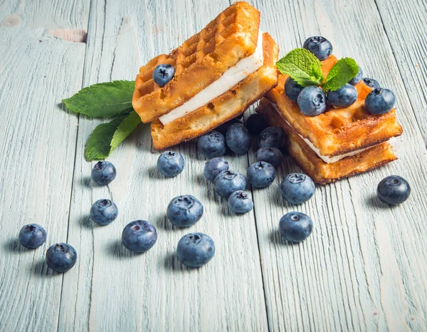 ahşap arka plan üzerinde beyaz bir tabakta nane ile yaban mersini