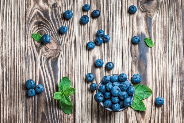 ahşap arka plan üzerinde beyaz bir tabakta nane ile yaban mersini