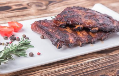 ızgara biftek pirzolası, altın kahverengi kabuklu ve beyaz tabakta baharatlı.