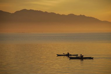 Lindau, Almanya: Bir görünümünü Bodensee (aka Bodensee), uzaktan Avusturya ve İsviçre, yaz aylarında gün batımında. Lindau pozisyonda: toz Kulesi (Almanca: Pulverturm)
