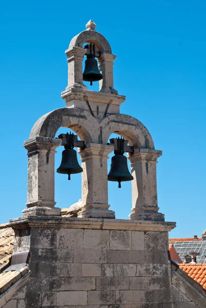 Three church bells hanging from a church tower in Dubrovnik's old town Stock Picture