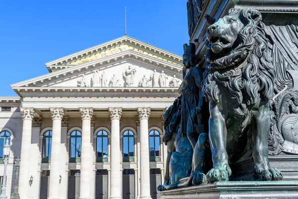 ミュンヘンのマックス ジョセフ記念碑でバイエルンのライオンの頭 強力な慎重さと正義のためのバイエルンの紋章動物やシンボル オペラ座を背景に ストックフォト