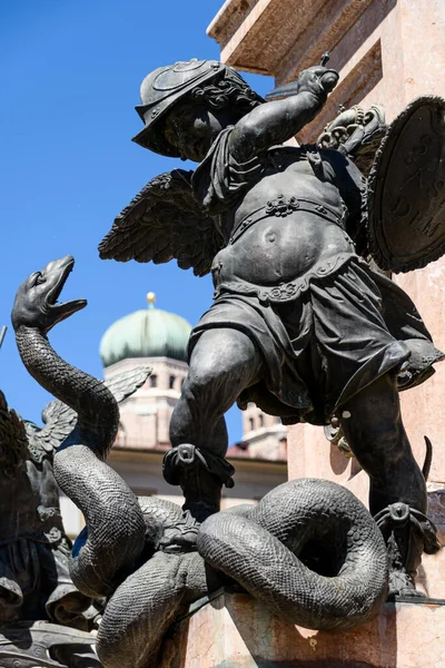 Munich, Germany: Sculpture at the base of the column on Marienplatz. Statue of a putto killing giant snake