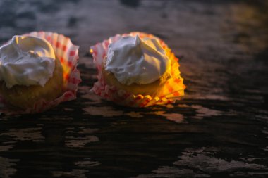 Güneş ışığı altında ahşap bir zemin üzerine cupcakes