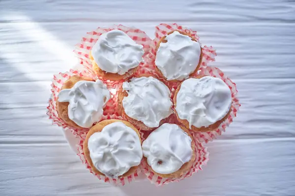 Cupcakes with white cream on a wooden background — Stock Photo, Image