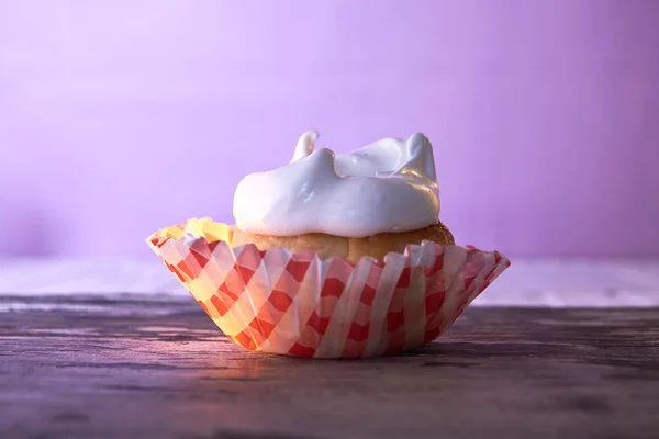 Cupcake with cream on a pastel background on a wooden table — Stock Photo, Image