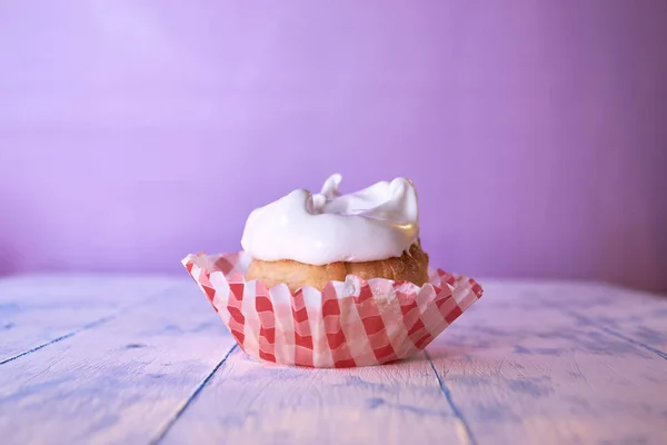 Cupcake with cream on a pastel background on a wooden table — Stock Photo, Image
