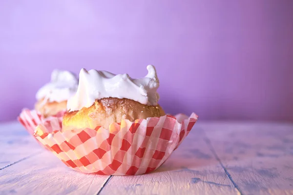 Cupcake dengan krim di latar belakang pastel di atas meja kayu — Stok Foto