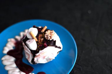 Siyah bir zemin üzerine mavi tabakta kek