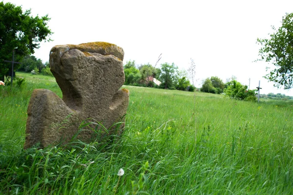 Vieja cruz de piedra en un prado verde — Foto de Stock