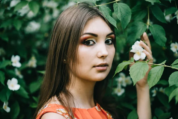 Vacker ung flicka i en röd sommar klänning i en park — Stockfoto