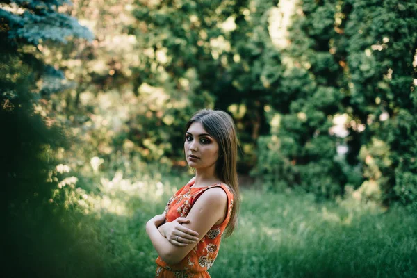 Krásná mladá dívka v červené letní šaty v parku — Stock fotografie