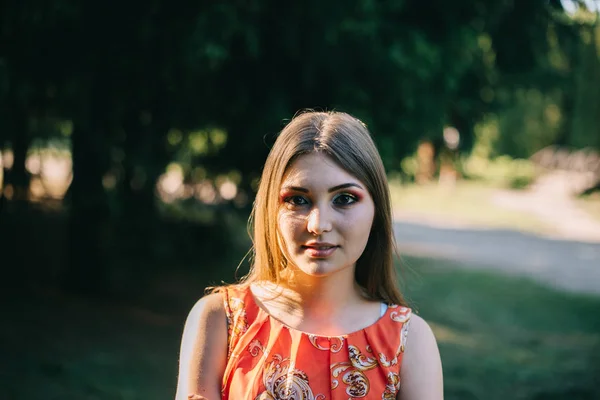 Hermosa joven en un vestido rojo de verano en un parque —  Fotos de Stock