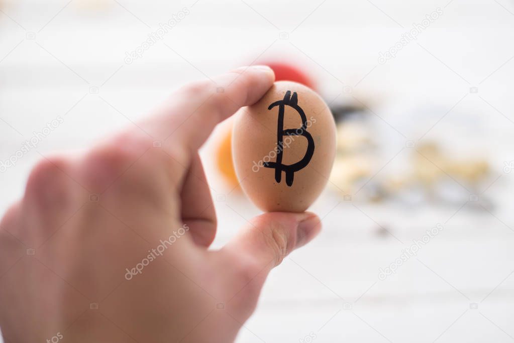 Egg with logo bitcoin in hand. The concept of Crypto-currency.