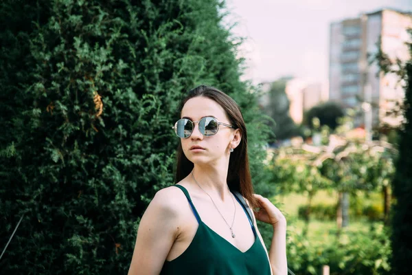 Menina bonita em um parque em óculos de sol — Fotografia de Stock