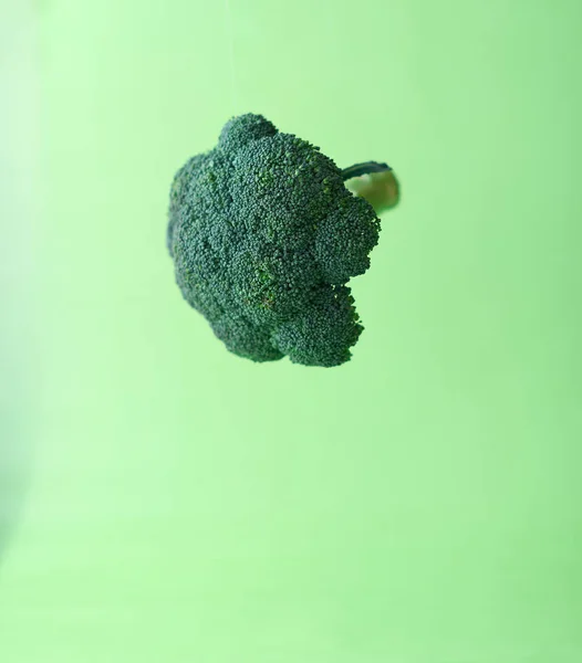 Brokuły w powietrzu na zielonym tle — Zdjęcie stockowe