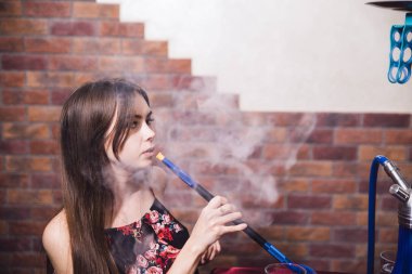 Genç güzel kız kulüp bir nargile sigara içiyor.