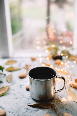 Sonbahar yaprakları ve Çerezler ile pencere yakınındaki çay Kupası